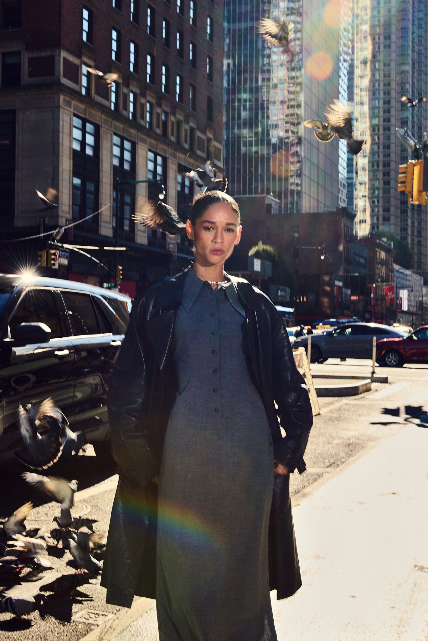 female model standing street pigeons sunlight new york fashion shoot
