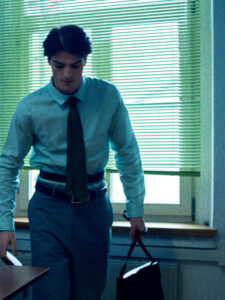 male model looking through green blinds office cinematic portrait