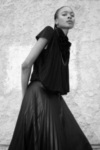 female model portrait wall black dress minimal fashion
