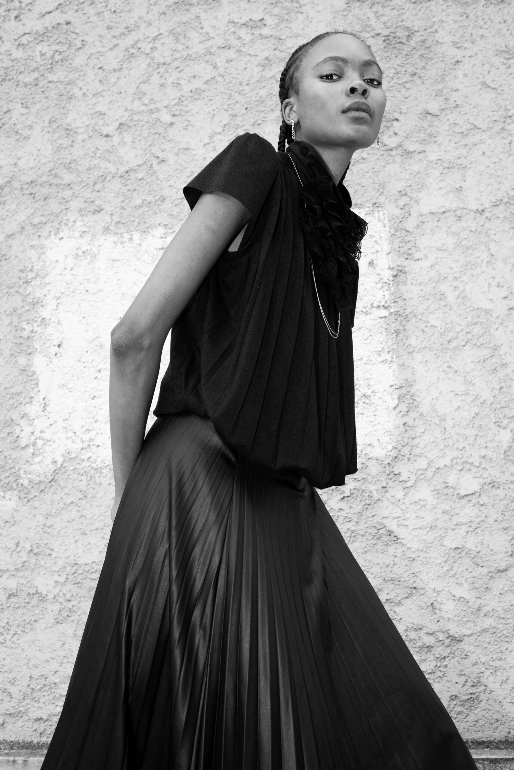 female model portrait wall black dress minimal fashion

